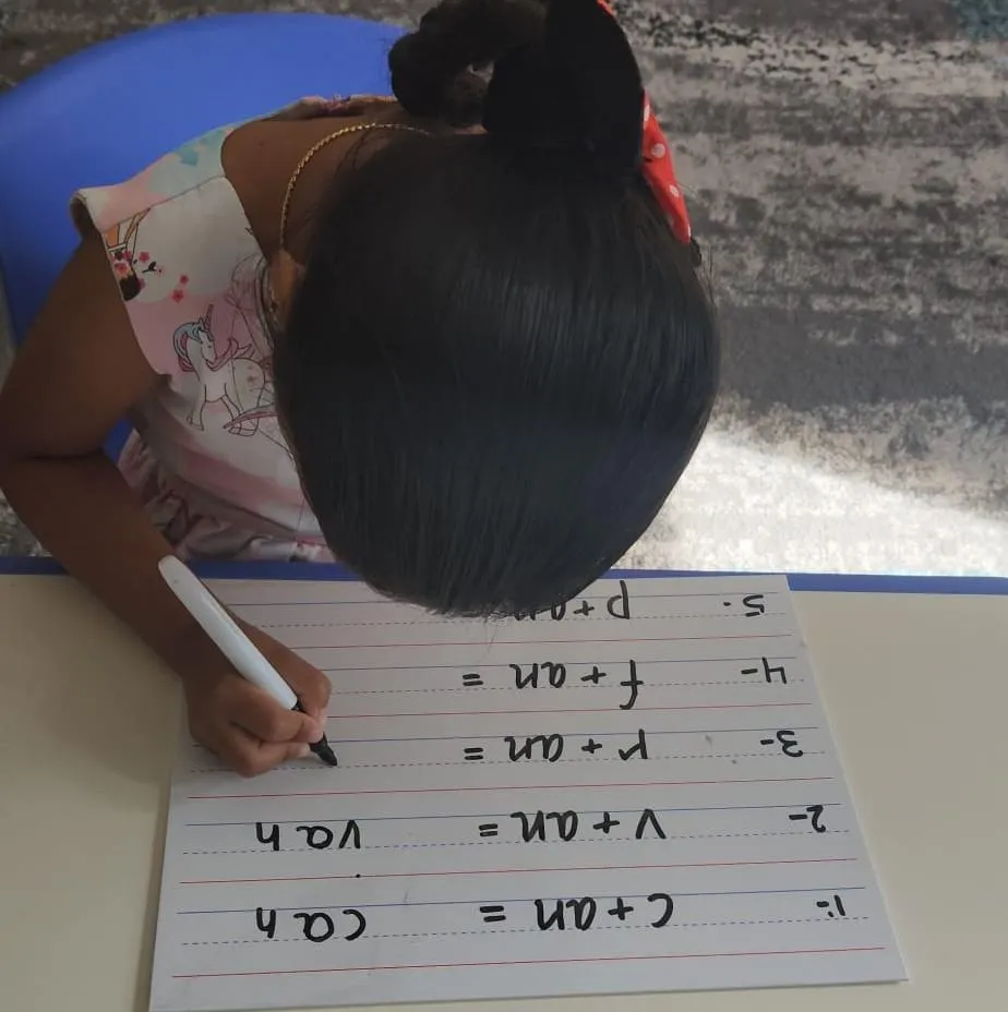 Girl stretches to the side while watching teacher on large screen TV