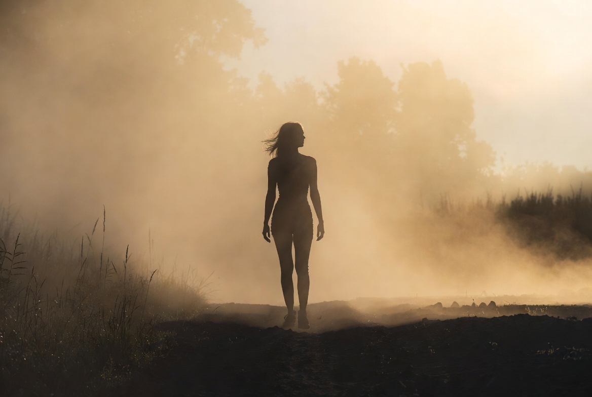 A serene and contemplative scene of a person standing in a gentle fog at dawn, no visible paths in front of them whatsoever. Soft, diffused morning light creates a peaceful, misty atmosphere.