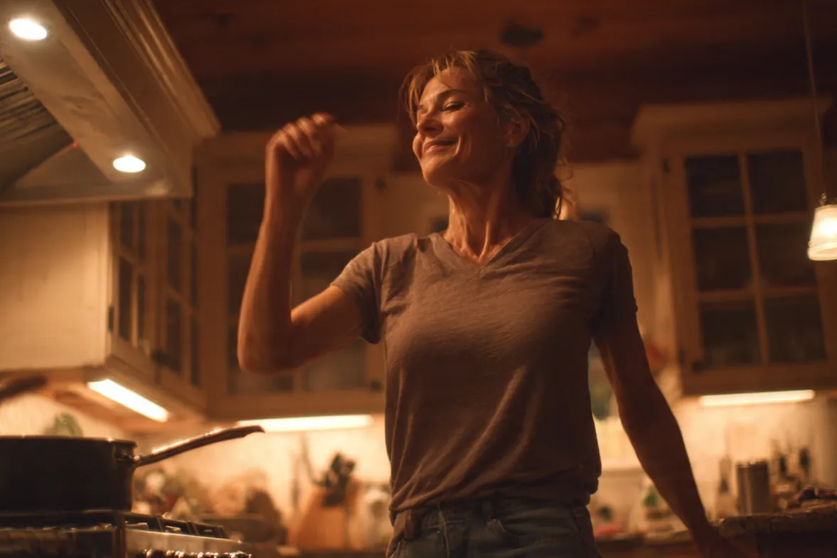 a woman getting dance exercise in while cooking dinner with a big smile happy scene