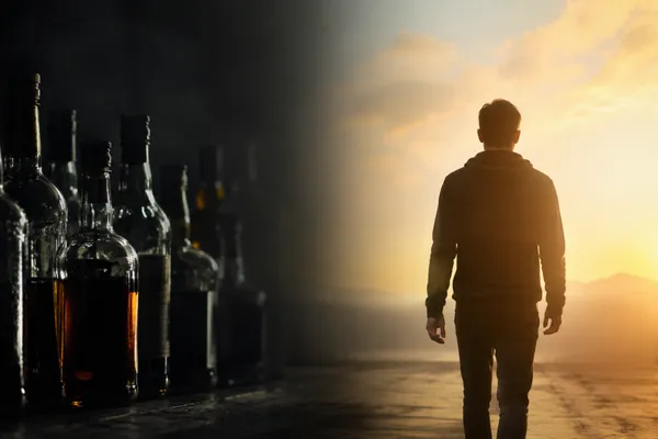 A split-composition image: on the left side, a dark, moody scene of alcohol bottles in shadow with harsh lighting; on the right side, bright golden morning sunlight breaking through, with a person's silhouette turning away from the darkness toward the light. The transition between dark and light is dramatic and cinematic. Symbolizes conscious choice, awakening, and moving from unconscious habit to intentional living.