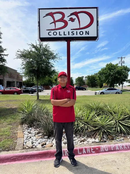 B&D Collision Apprenticeship student Orlando Jacobo standing in front of the Mesquite location sign