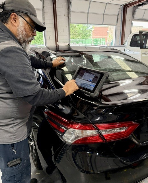 i-Car certified tech at the back of a car using an ADAS Calibration system
