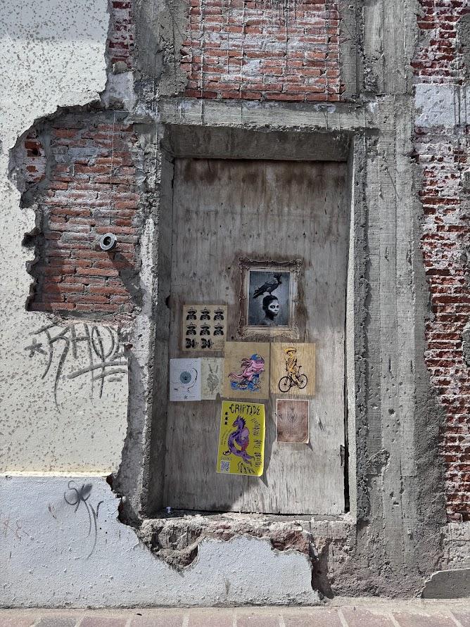 brick wall with various small street art posters 