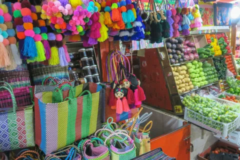 mercado stall with colorful pom poms and bags