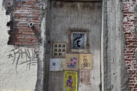 Street Art on Brick Wall. Images include person on bike, person with bird on head.