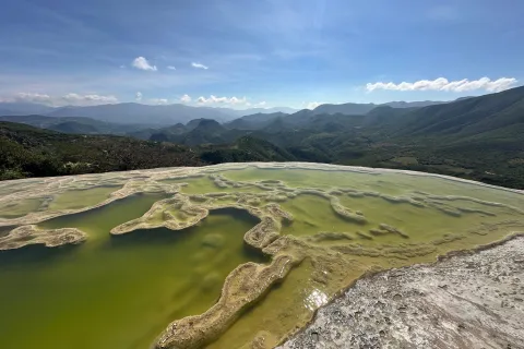 hot spring with mountains in the background 