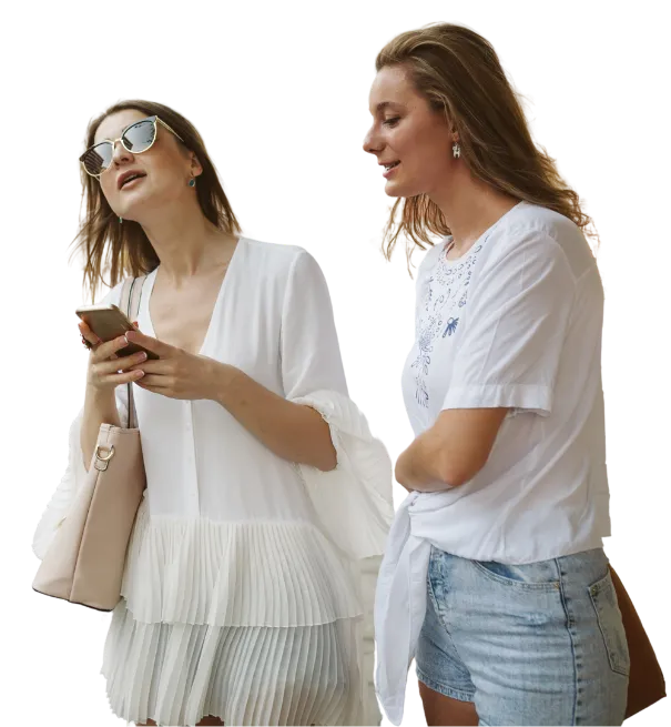 Two girls waiting for a ride; one checking the route on her phone, the other watching the screen.