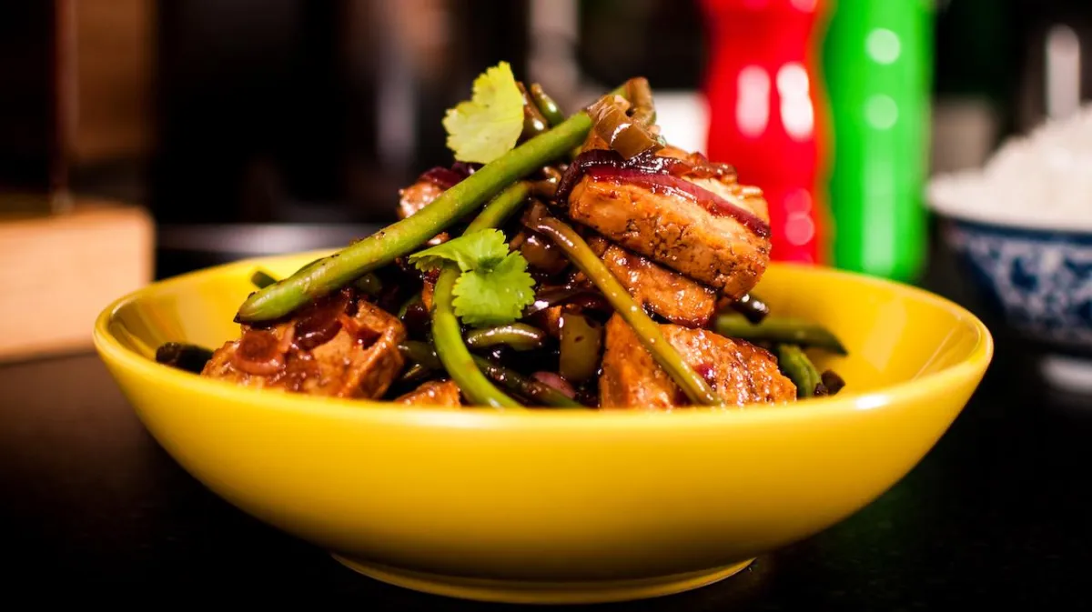 An Asian stir fry dish, with tofu, placed on a table; homemade whole food suitable for vegans