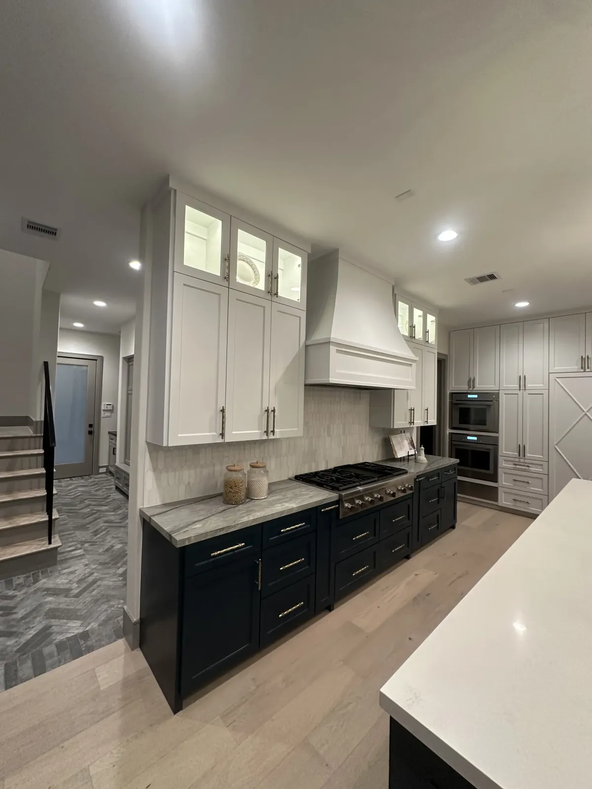 Professional kitchen painter in Cypress, Texas, spray painting kitchen cabinets with protective equipment and drop cloths for quality results