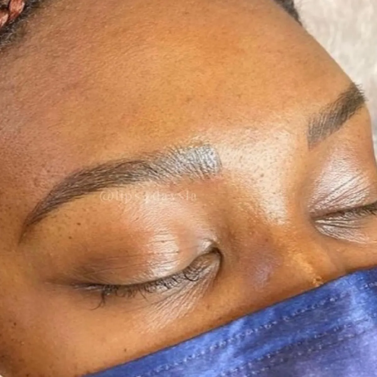 Up close microbladed eyebrows on a dark skinned woman with medium brown pigment