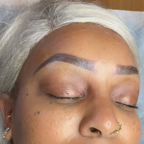 Medium thick powder brows with brown pigment  on a dark skinned woman. 