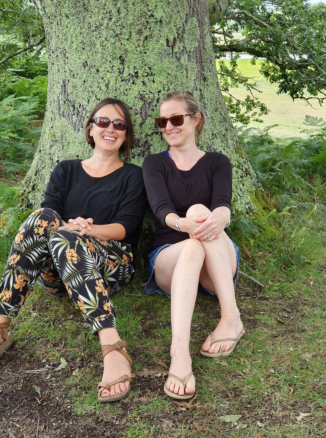 Louisa & Lee-anne enjoying the sun against a tree