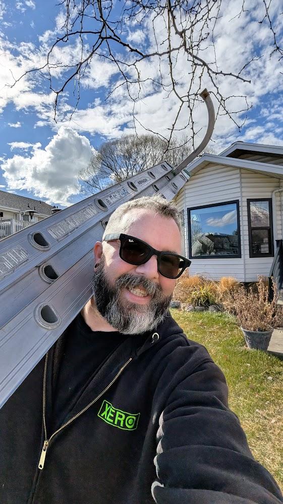 James Riley, founder of Zen Window Cleaning, carrying a ladder at a residential job site in Provo, Utah.
