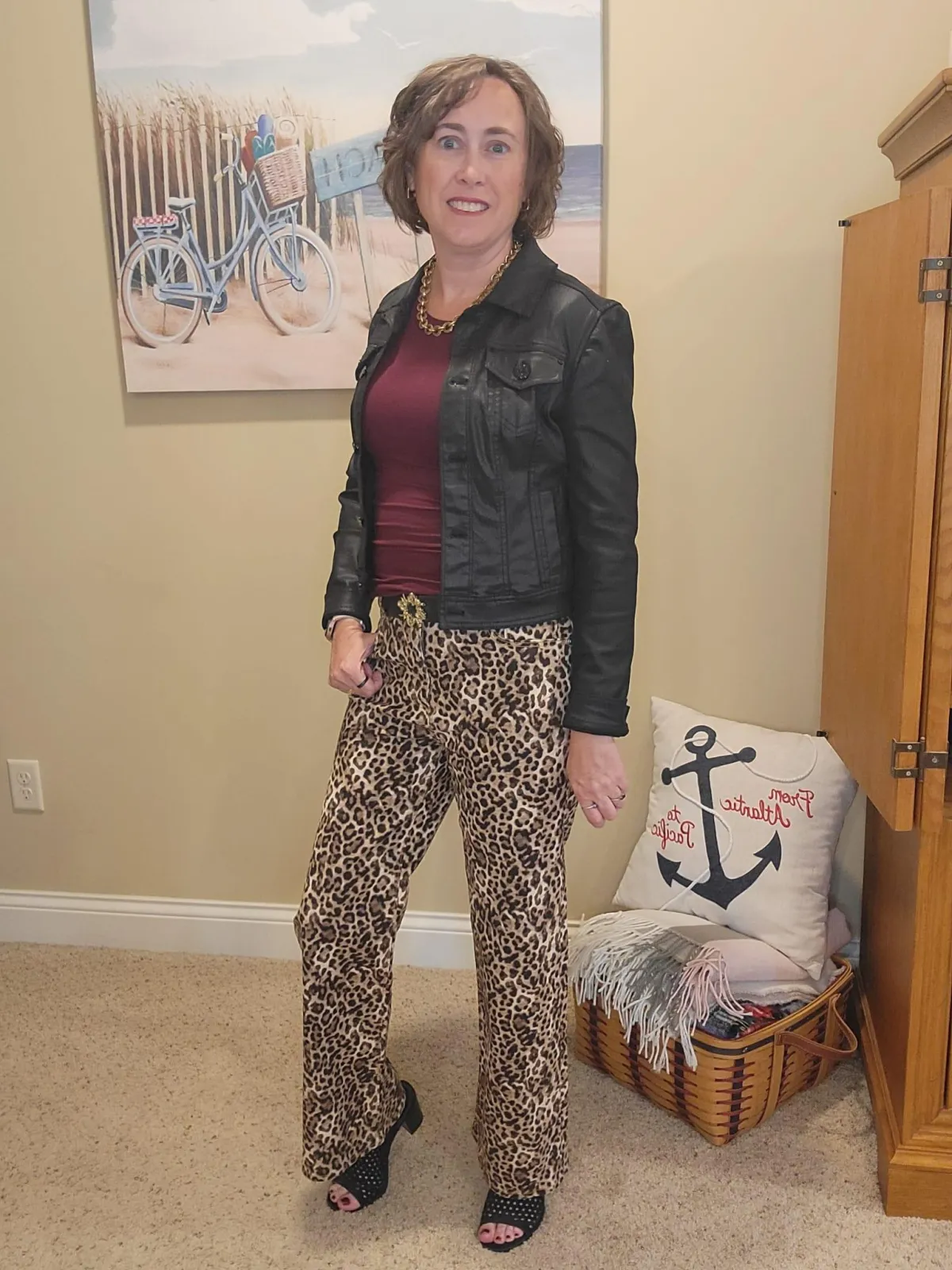 Jenn Whitacre wearing a black coated denim jacket over a burgundy long-sleeve tee with Loft leopard print jeans, gold necklace, black belt, and black heeled sandals — elevated fall outfit inspiration by Styled by Jenn.