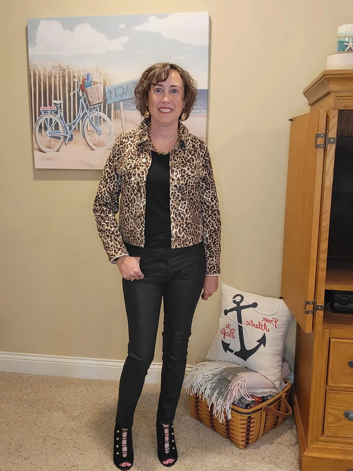 Jenn Whitacre wearing a Loft leopard print denim jacket over a black top with WHBM black coated denim jeans, black booties, gold necklace, and earrings — chic fall outfit inspiration by Styled by Jenn.