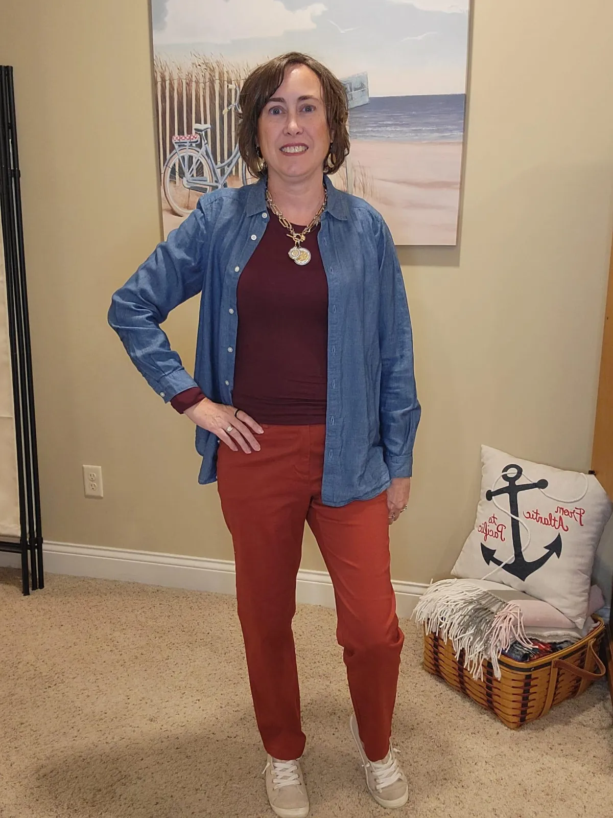 Jenn Whitacre wearing a Loft denim shirt over a burgundy long-sleeve tee with rusty pumpkin pants, beige sneakers, and a gold necklace — fall layered outfit inspiration by Styled by Jenn.