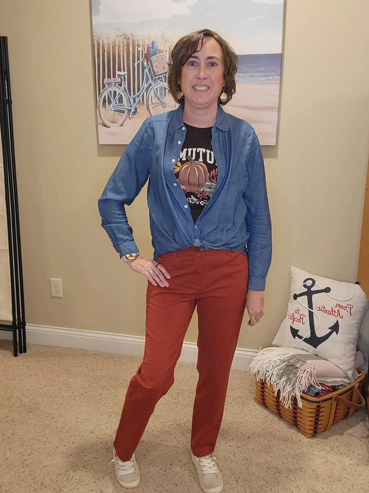 Jenn Whitacre wearing a Loft denim shirt layered over a brown fall graphic tee with rusty pumpkin pants and beige sneakers — effortless layered fall outfit by Styled by Jenn.