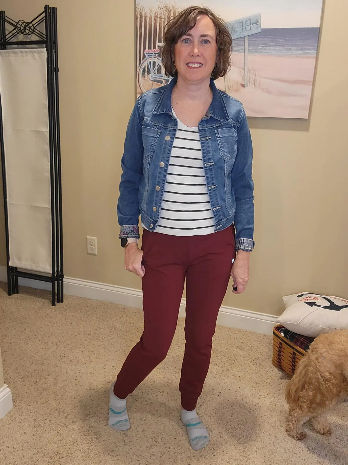 enn Whitacre wearing a WHBM teal tweed jacket over a light teal v-neck top, styled with gold jewelry, black bootcut jeans, and black boots for a chic and polished look.