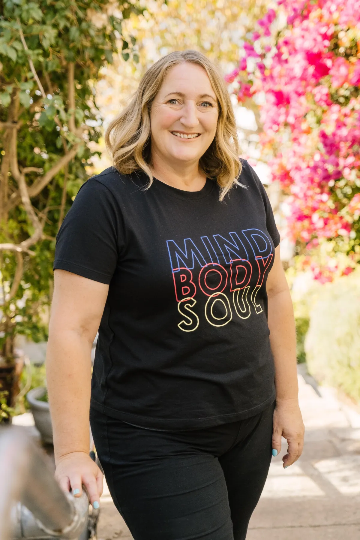 Smiling client testimonial portrait representing successful midlife transformation through coaching.