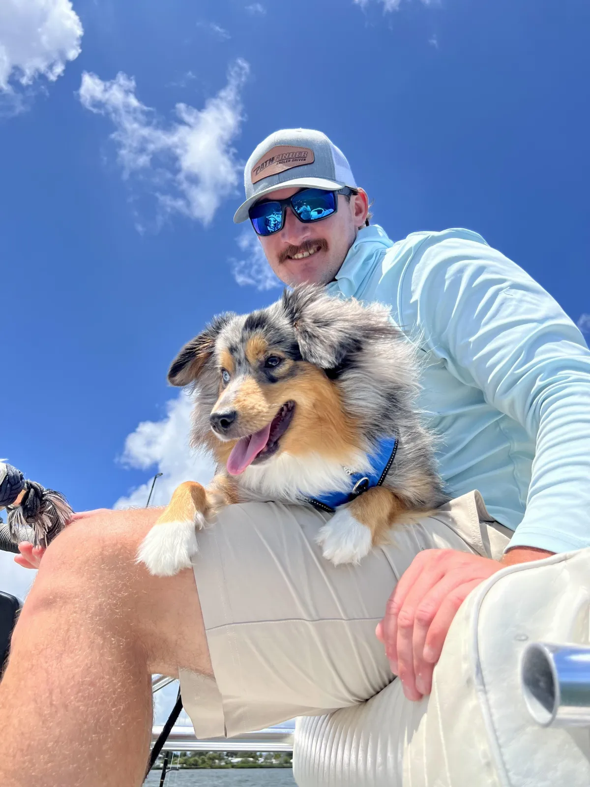 Captain Tanner smiling on a boat with his dog during a fishing charter in Pine Island, Florida