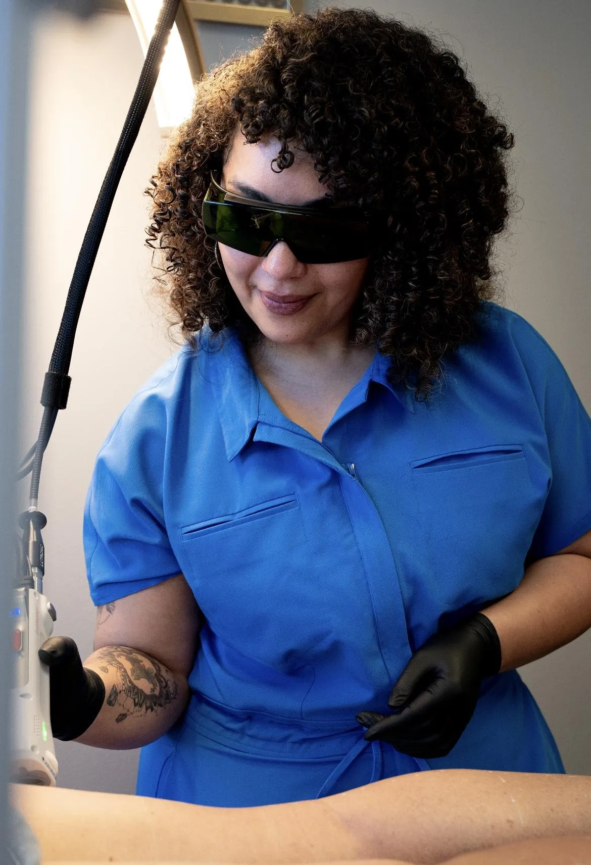 woman in black tank top sitting on brown wooden log during daytime