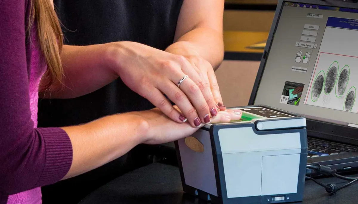 Technician assisting client with Live Scan fingerprinting in San Diego for background checks