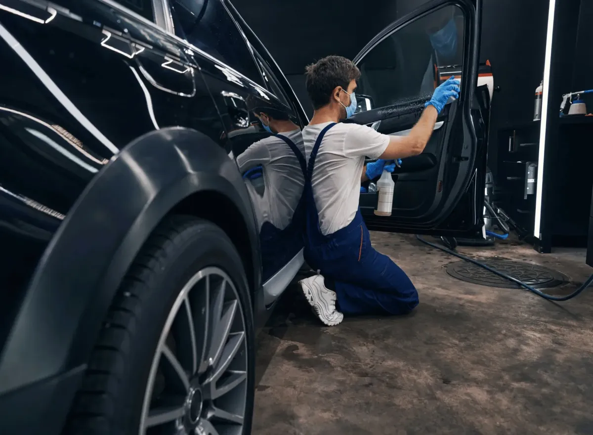 Applying window tint film to a car door window in Roanoke, ensuring precise fit and professional finish.
