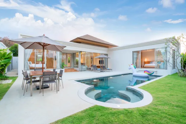 A stunning modern villa featuring a pool and patio area, creating a perfect blend of luxury and relaxation.