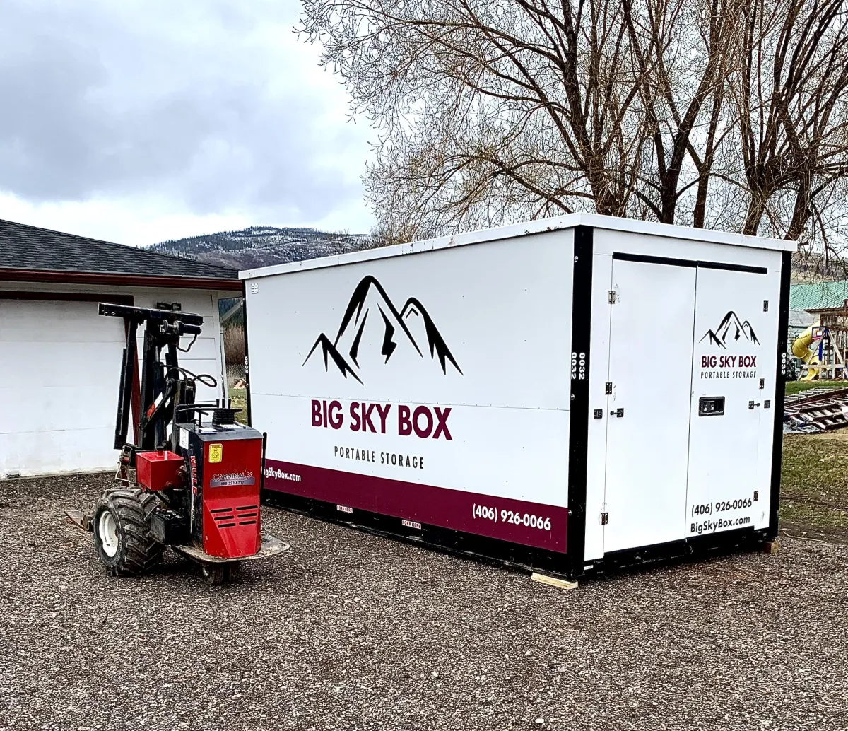 Image of a Big Sky Box Portable Storage in Missoula container in a driveway next to the mule delivery vehicle