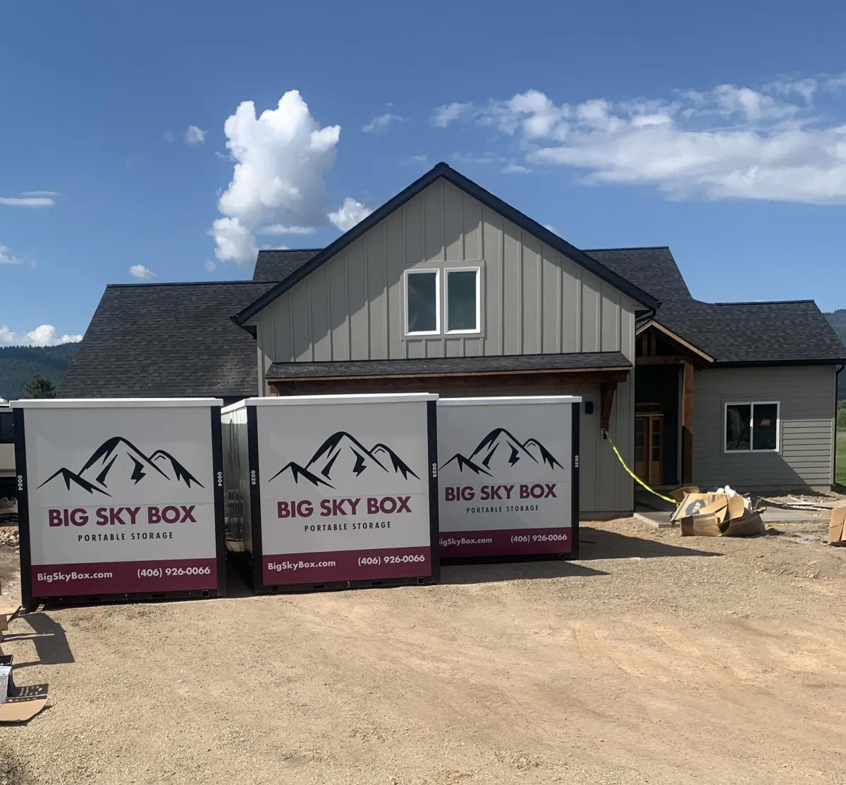 Three portable storage in Hamilton, MT containers in front of a new construction house