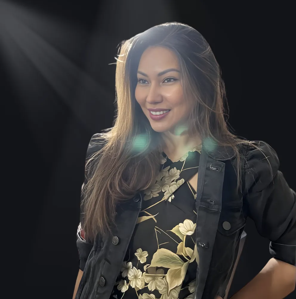 Neslyn Sellers standing on a sunlit coastal cliff, wind in her hair, gazing at the horizon with a serene expression. The background features a vibrant blue sea and golden sky, evoking a sense of peace and possibility. 3:2 aspect ratio.