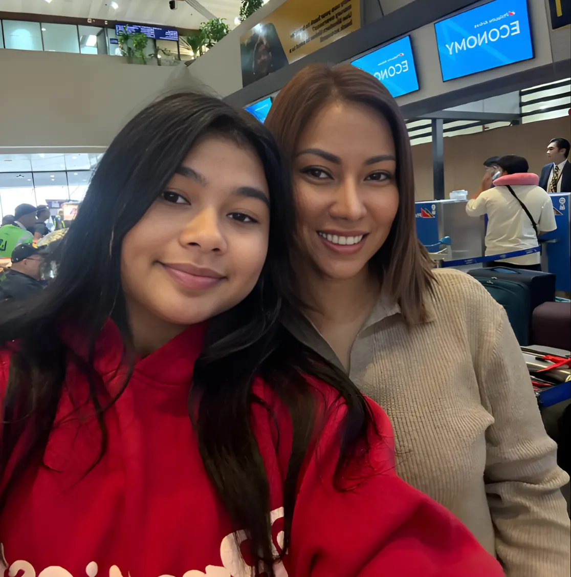 Candid shot of Neslyn laughing with local children in a Peruvian village, adobe houses and mountains in the background. The moment is joyful and spontaneous, capturing genuine connection. 1:1 aspect ratio.