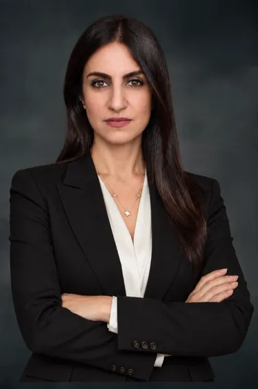 Maryam Jahedi-Perez, founding attorney of Maryam Jahedi Law Firm P.C., smiling in a blue floral dress against a dark background, representing legal expertise in criminal, divorce, and family law.