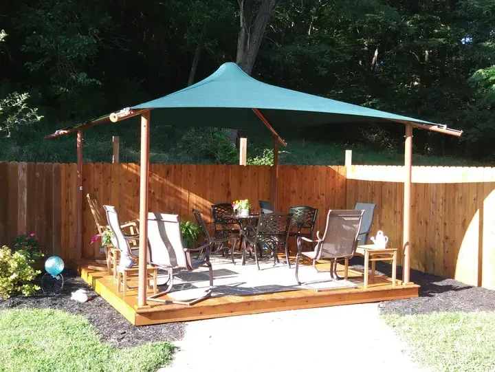 Duffer Hollow Designs structure placed in a backyard with a seating area underneath.