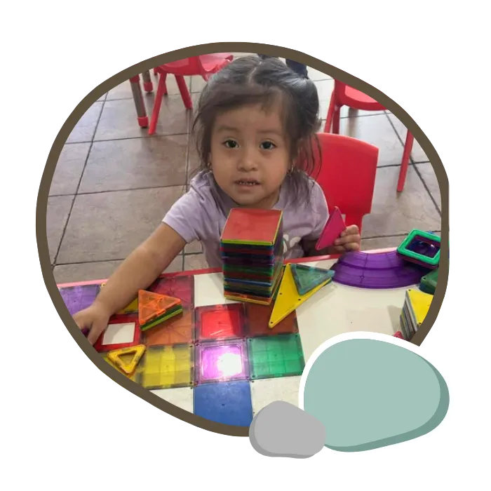 Toddlers exploring sensory materials in a Frog Street learning station at Pebblestone Academy