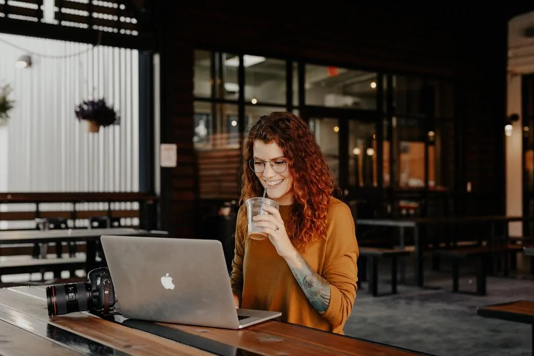 Small business owner chatting with website visitors using web chat widget on laptop