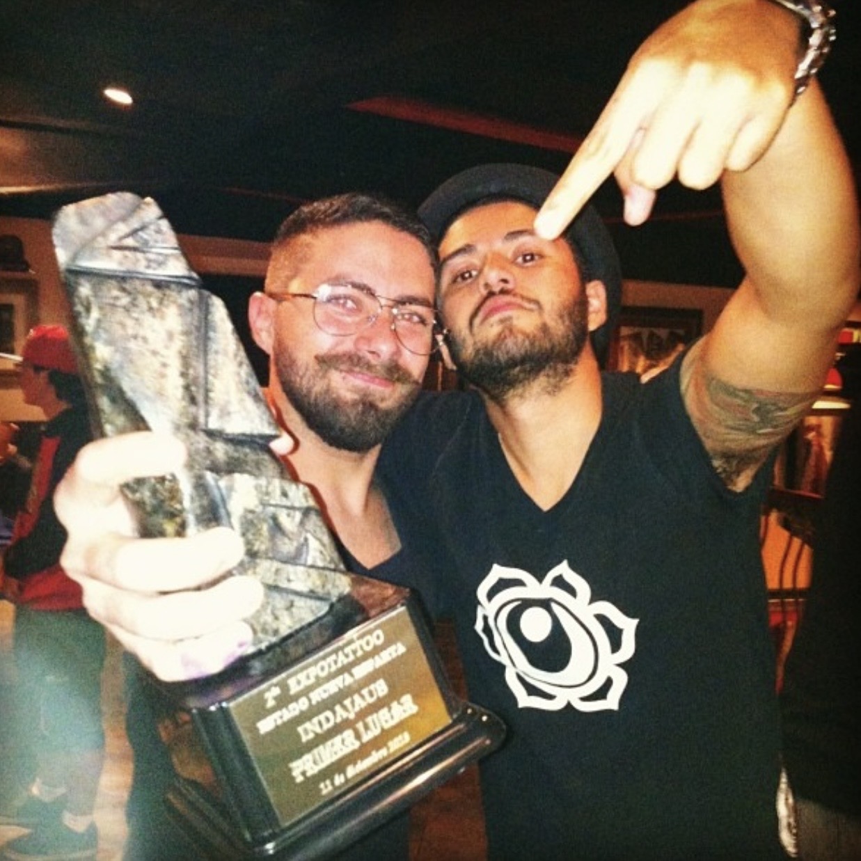 David Mendoza sosteniendo el premio de mejor tatuaje del evento de la exposición de tatuajes de Margarita en el 2013 junto a su amigo Gustavo.