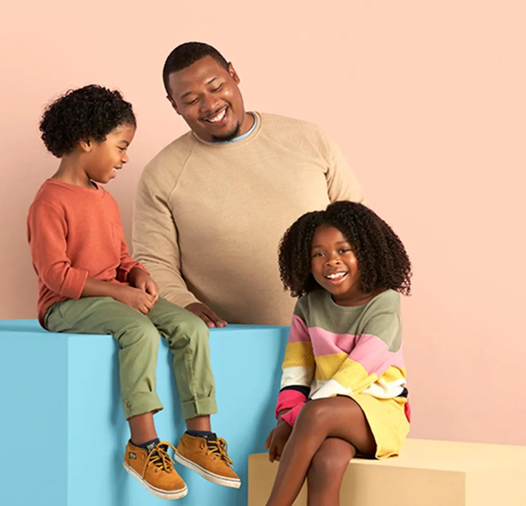 A father sitting with his son and daughter