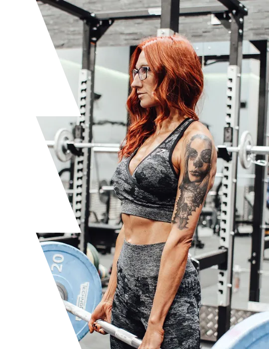 Woman performing a deadlift in a gym, wearing athletic gear and showcasing strength and confidence as part of her personal training routine.