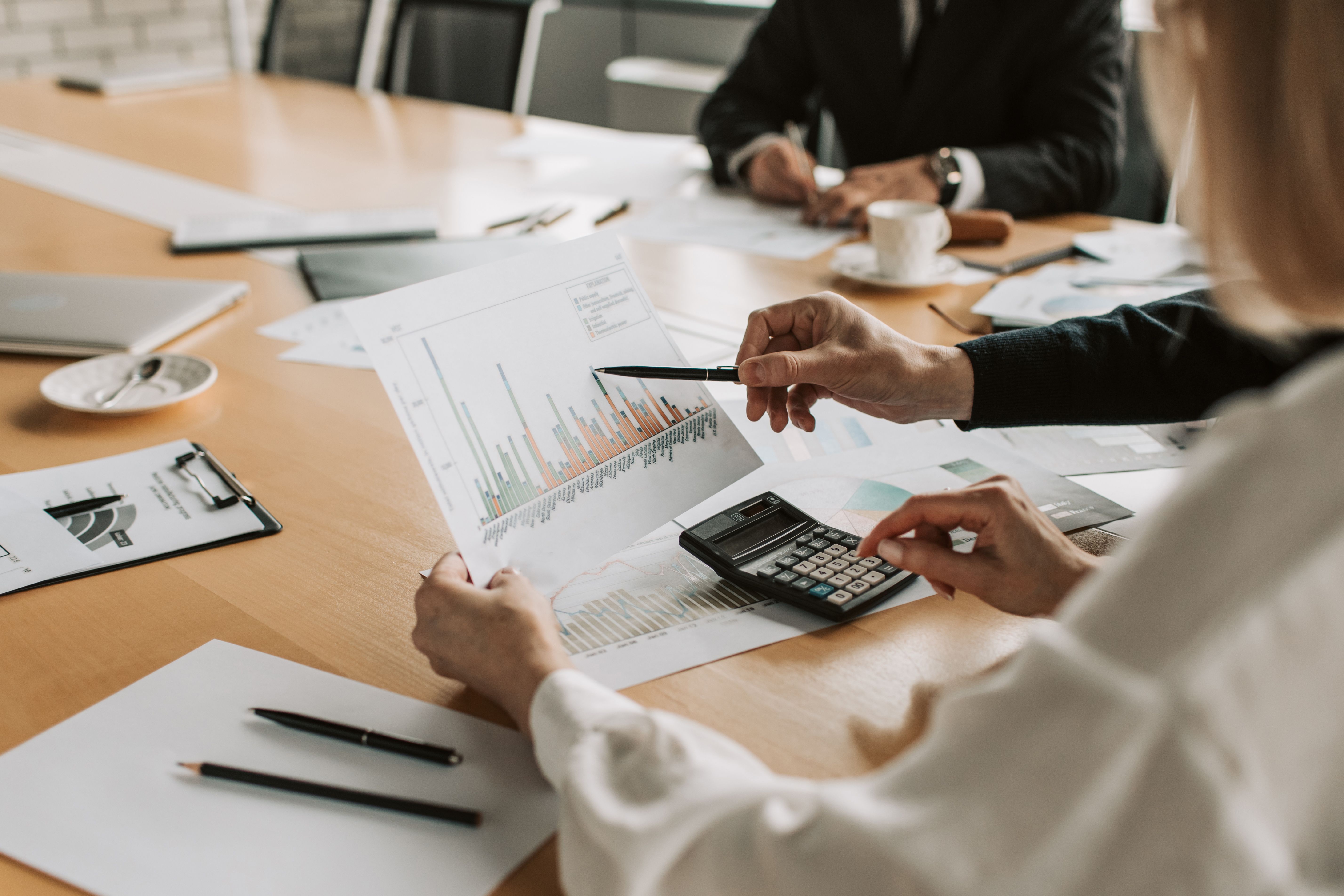 A man presents a graph to colleagues in a meeting.
