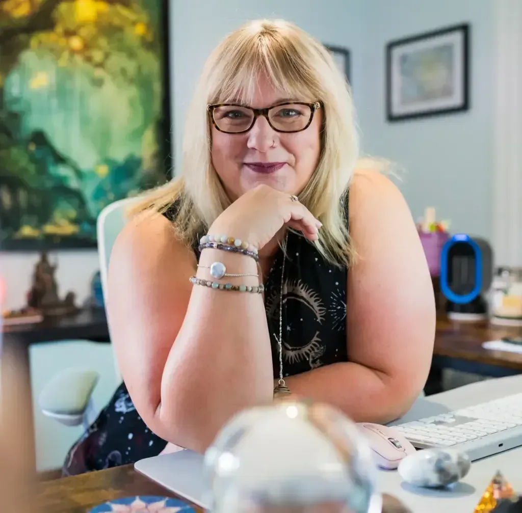 Tami With Crystal Ball sitting at her desk in her office.