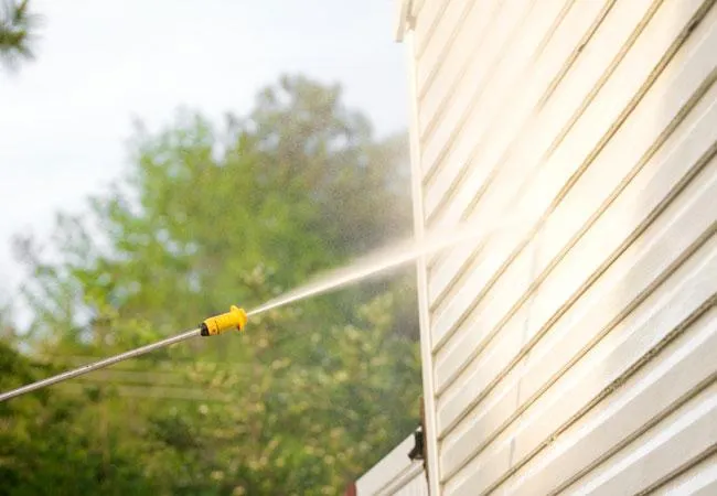 pressure washing the siding of the house