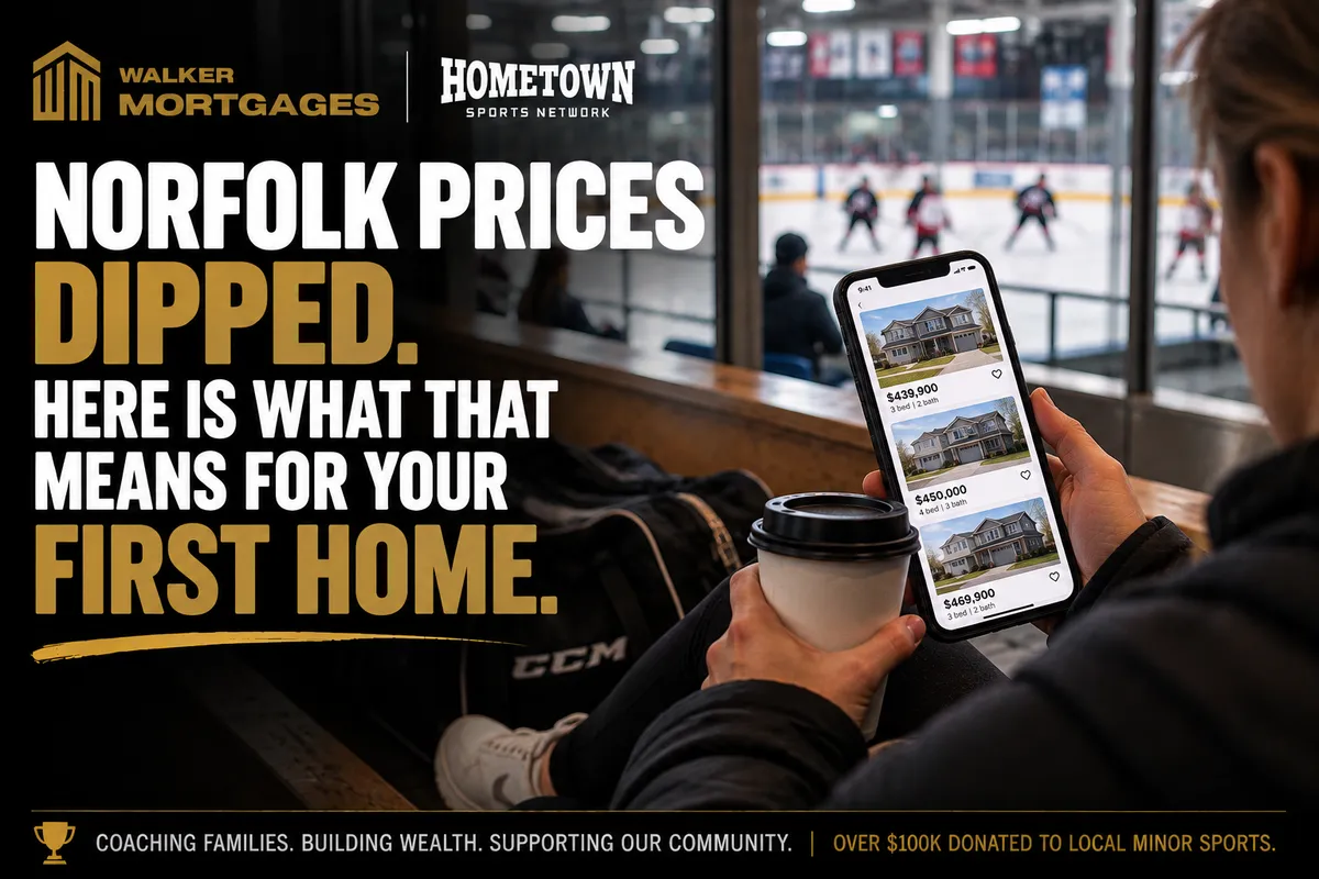 A parent scrolling home listings on a phone in an arena lobby with a coffee while a practice runs behind the glass