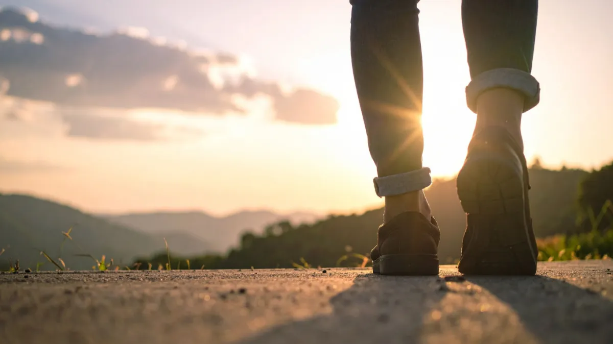 A diverse group of parents and a coach gathered around a table, engaged in a supportive discussion. The coach gestures encouragingly, while parents take notes and share experiences. The setting is a bright, welcoming community center with inclusive posters on the walls.