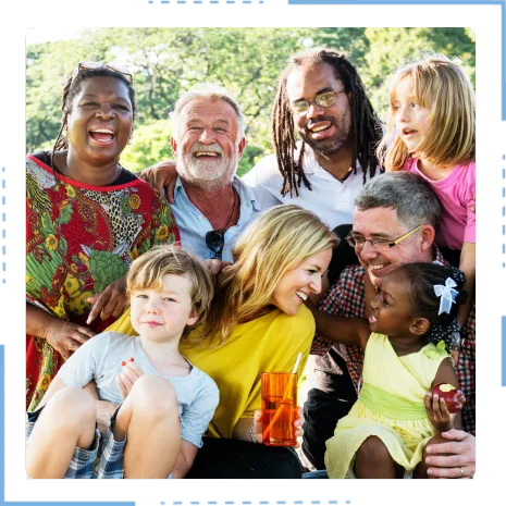  A diverse group of adults and children laughing and smiling outdoors, fostering community, perfect for owner finance land.