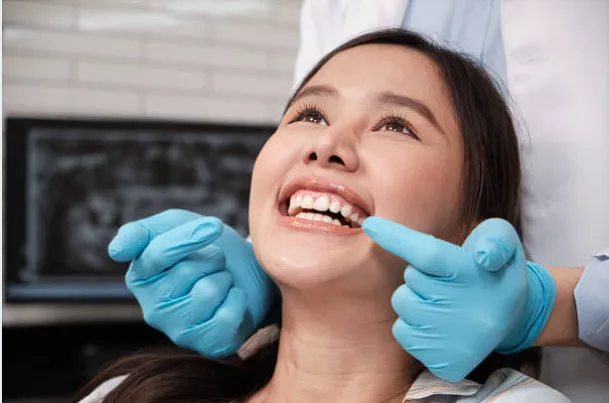 Dentist pointing to patient's smile during smile design consultation