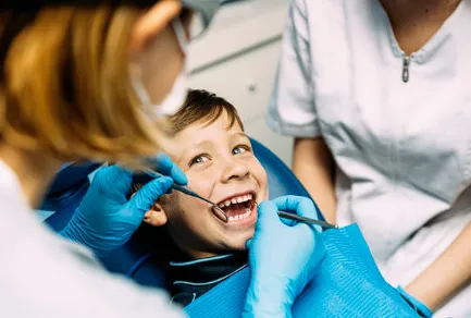 Smiling child receiving dental checkup from pediatric dentist