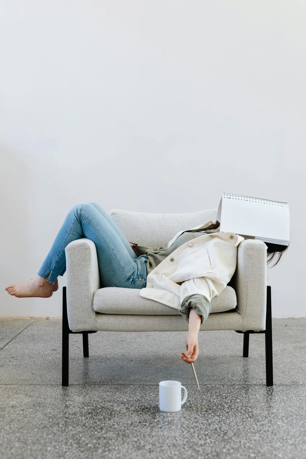 woman on couch with book on face