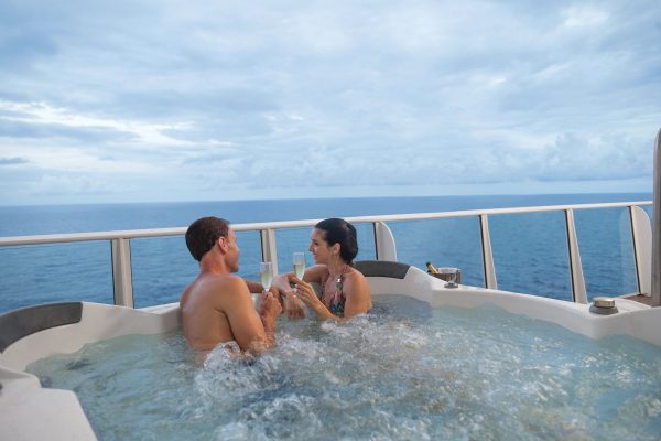 A couple enjoying a hot tub while sailing on a cruise ship