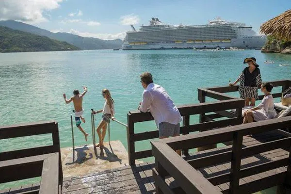 A family enjoying their caband overlooking the ocean and a cruise ship in the background.